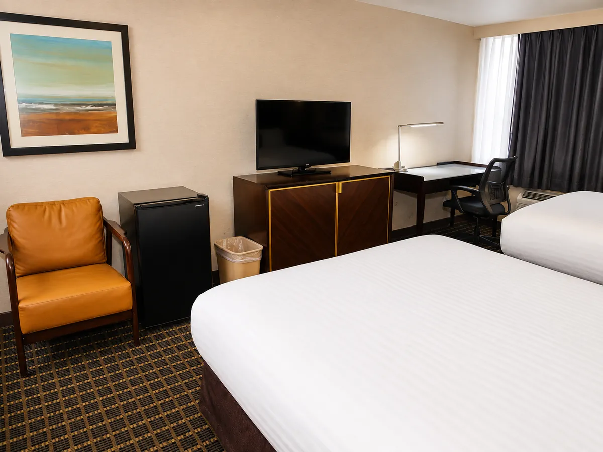 Queen room with two beds, workspace and armchair